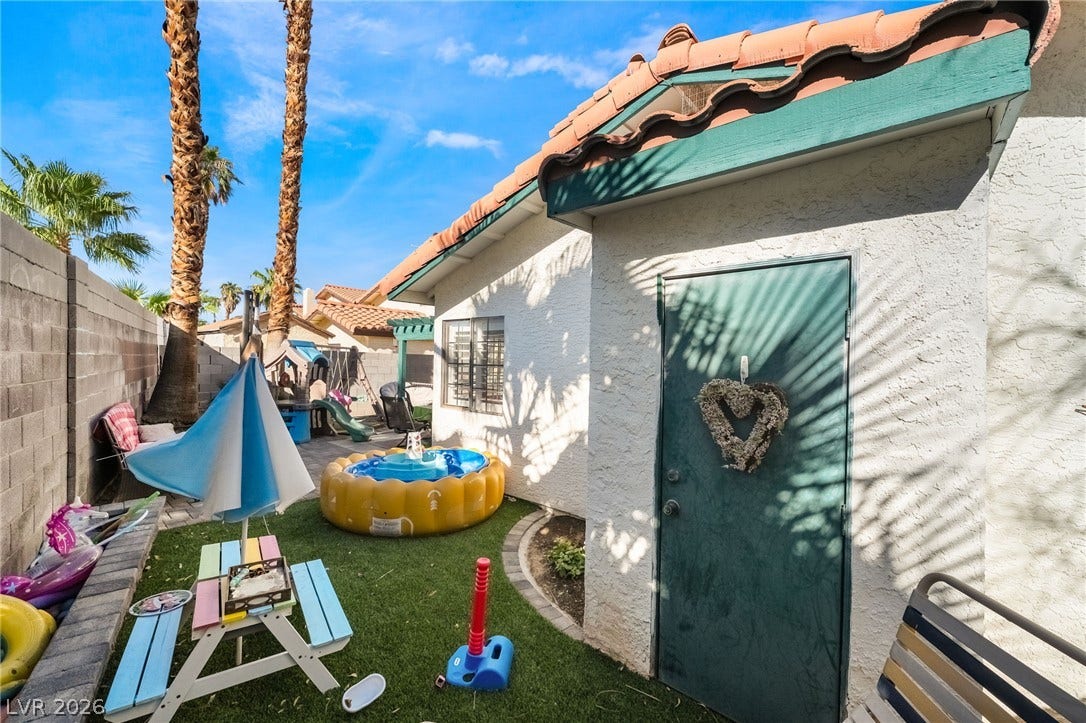 A private outdoor side yard features a block wall border and tile rooflines.