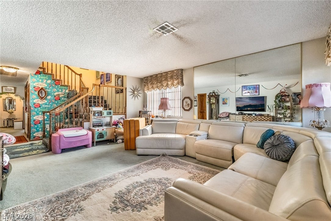 Mirrored walls and an open wooden staircase enhance this spacious main level living area.