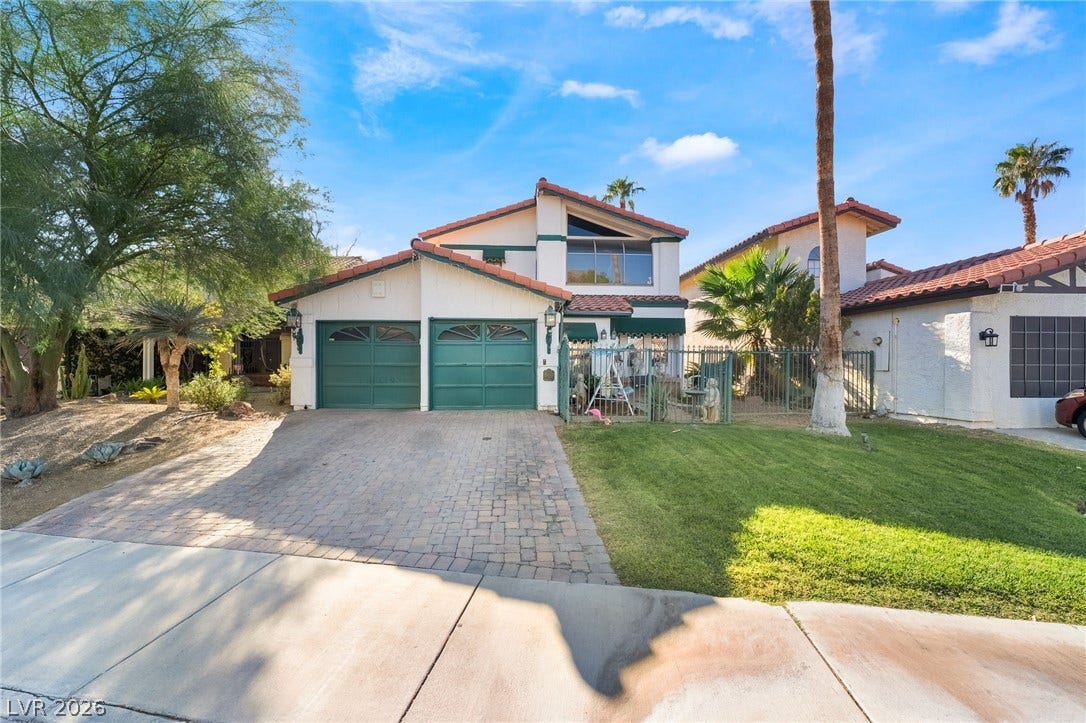 Spanish tile roofing and a paved driveway enhance this classic multi-level residence.