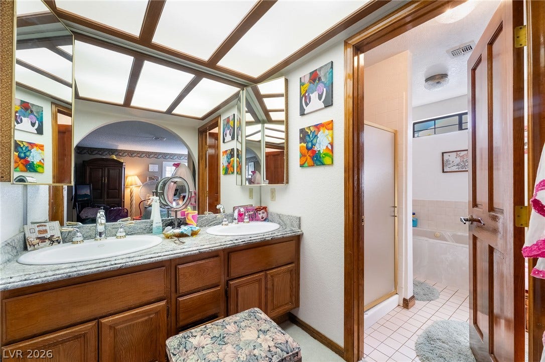 A spacious vanity area connects seamlessly to a private bathroom with a soaking tub.