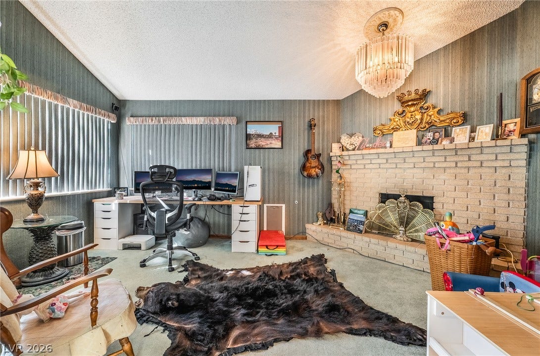 An inviting brick fireplace and textured walls anchor this versatile living area with vaulted ceilings.