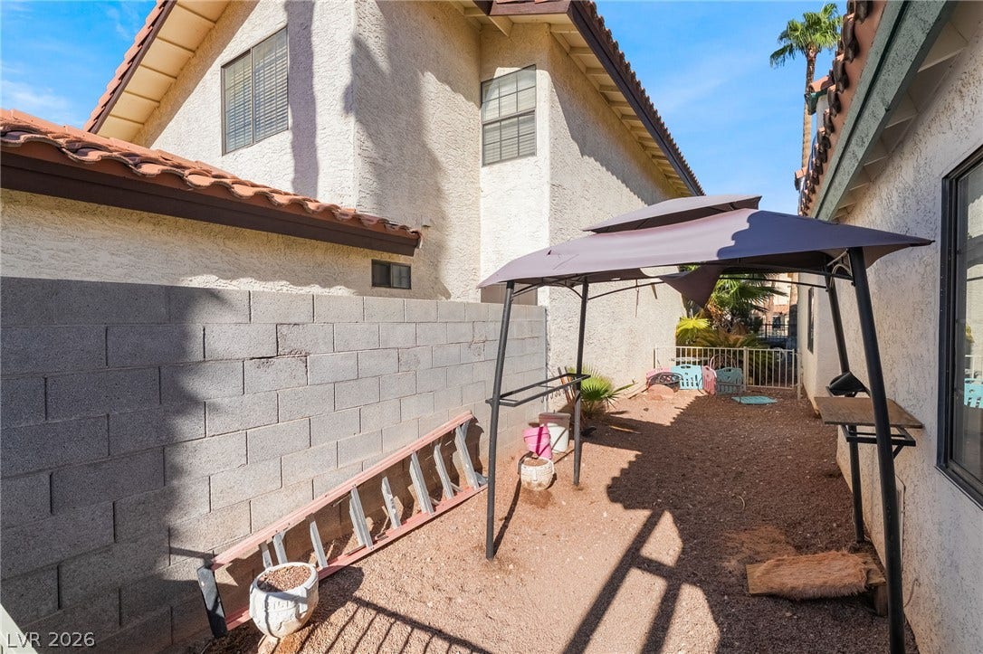 A private outdoor side yard enclosed by block wall fencing alongside the home.