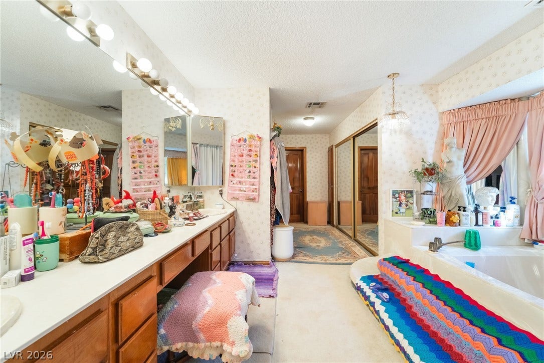 A spacious bathroom layout presents an integrated vanity counter alongside a built-in soaking tub.