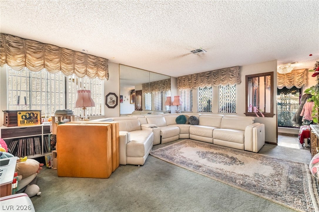 Multiple windows and a large mirrored wall panel bring ample light to this spacious room.