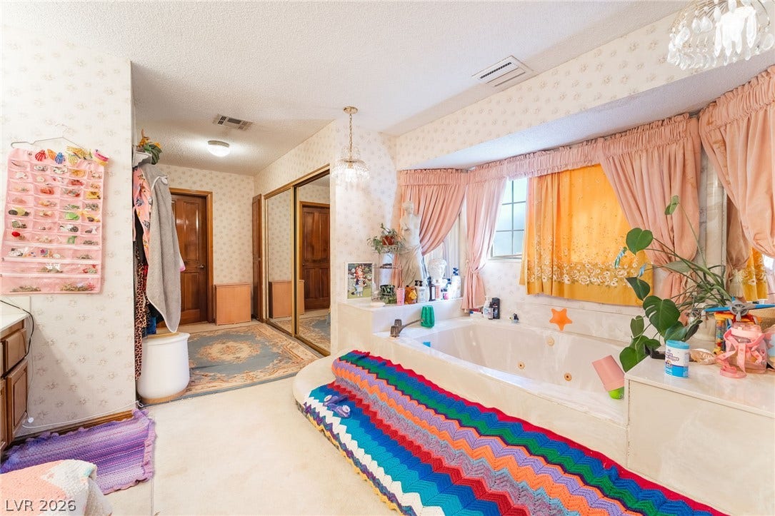 An integrated soaking tub and mirrored closet doors define this primary bathroom layout.