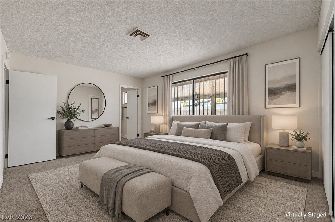 4442 Eureka Circle, Las Vegas, NV 89103 A spacious bedroom features soft neutral walls, classic crown molding, and plush carpeting underfoot.