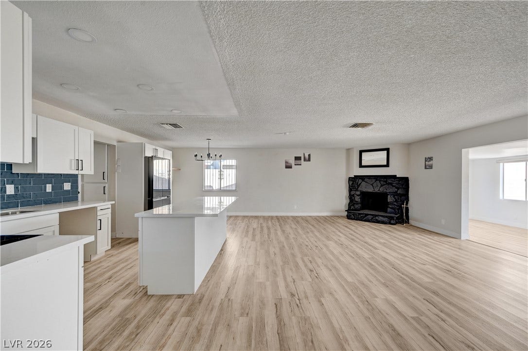 4442 Eureka Circle, Las Vegas, NV 89103 An open floorplan seamlessly connects the updated kitchen to a spacious living area with fireplace.