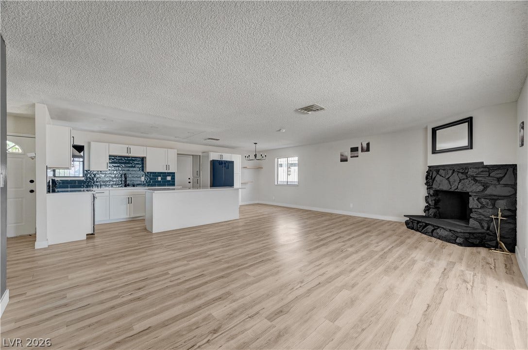 4442 Eureka Circle, Las Vegas, NV 89103 Smooth wood flooring runs throughout this expansive open layout featuring a rustic stone fireplace.