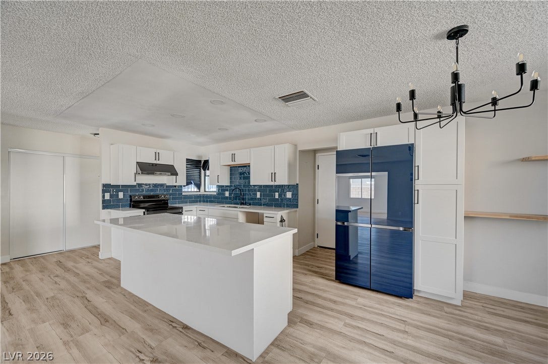 4442 Eureka Circle, Las Vegas, NV 89103 An open kitchen layout showcases sleek countertops, custom cabinetry, and modern wood-look flooring.