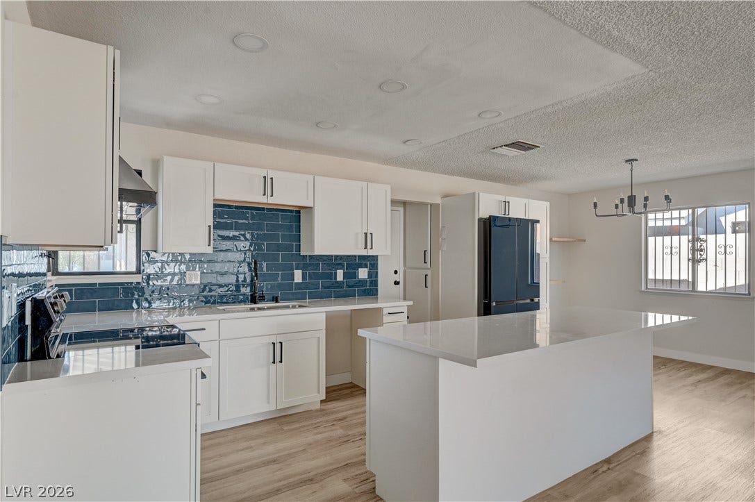 4442 Eureka Circle, Las Vegas, NV 89103 Polished stone countertops pair elegantly with rich tile backsplashes in this modern culinary space.