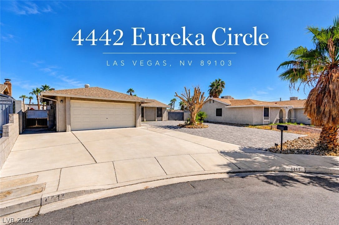 4442 Eureka Circle, Las Vegas, NV 89103 A spacious concrete driveway leads to an attached two-car garage under clear desert skies.