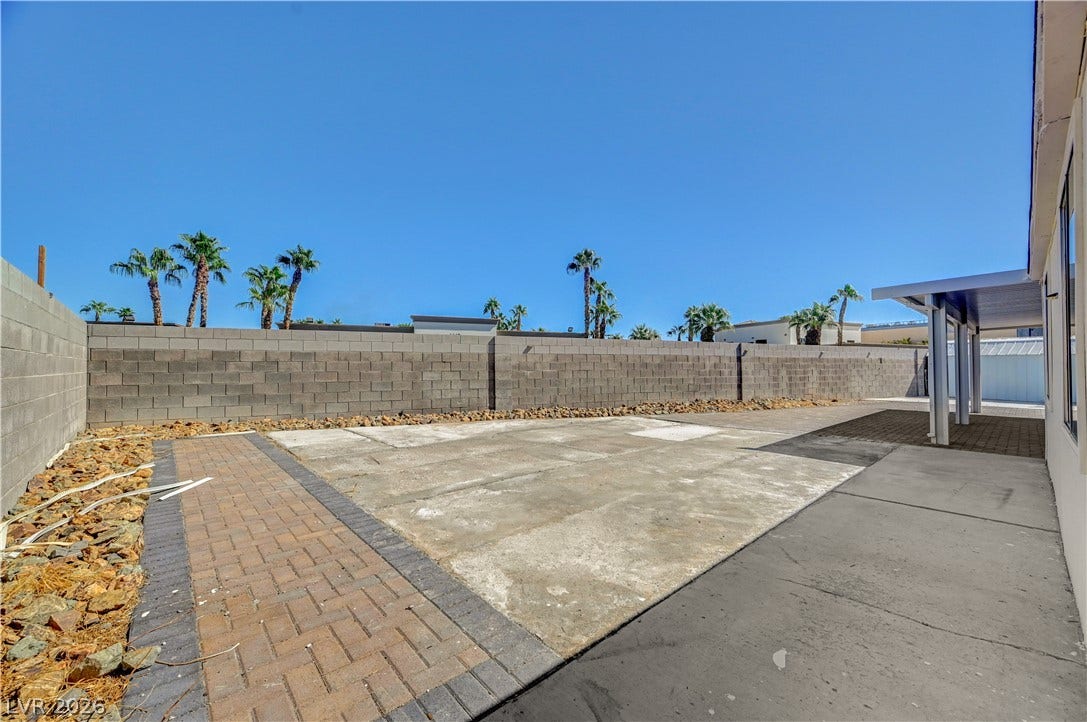 4442 Eureka Circle, Las Vegas, NV 89103 A spacious backyard patio area is enclosed by a privacy block wall under clear desert skies.