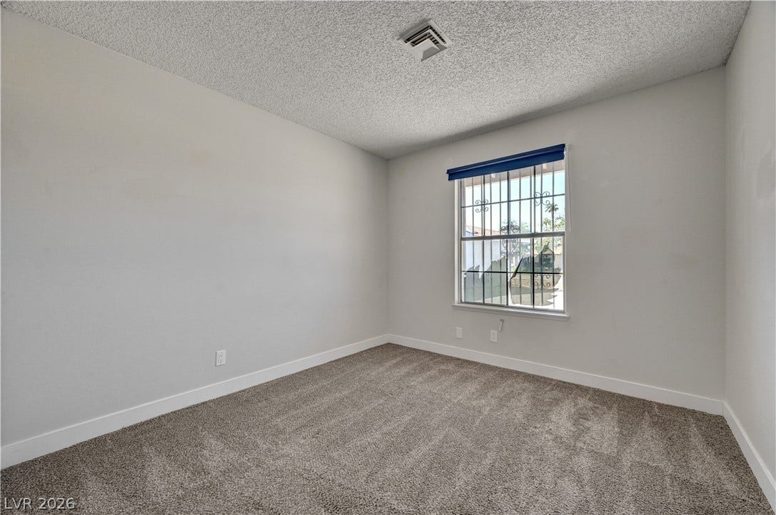 4442 Eureka Circle, Las Vegas, NV 89103 Soft carpeting pairs with neutral walls and a security-barred window in this quiet bedroom.