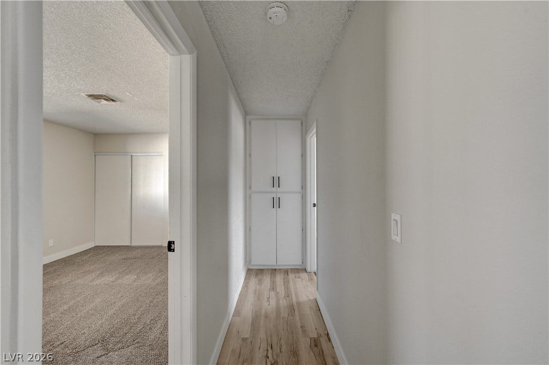 4442 Eureka Circle, Las Vegas, NV 89103 Smooth wood-style flooring complements neutral walls and built-in hallway cabinetry.
