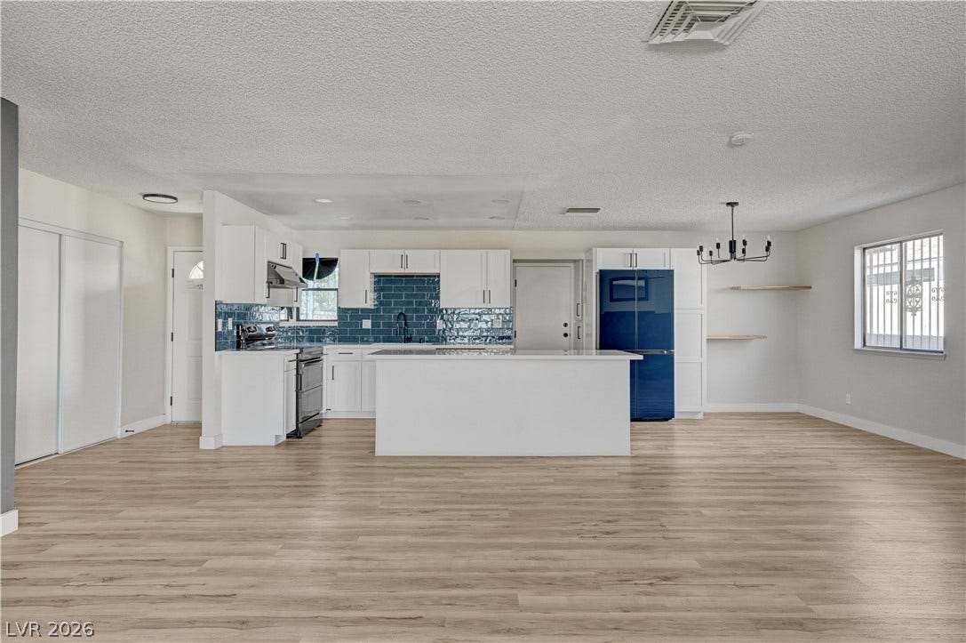 4442 Eureka Circle, Las Vegas, NV 89103 Clean wood-look flooring stretches across an open concept layout with an updated island kitchen.