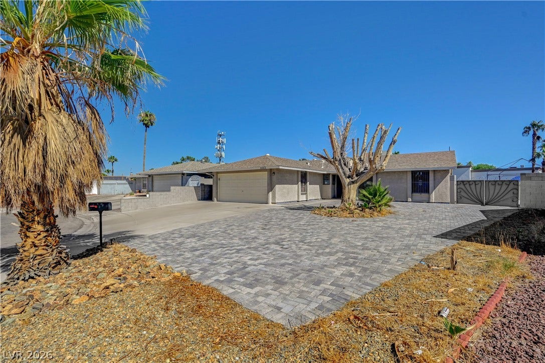 4442 Eureka Circle, Las Vegas, NV 89103 A spacious paved driveway leads to a single-story ranch home under clear blue skies.