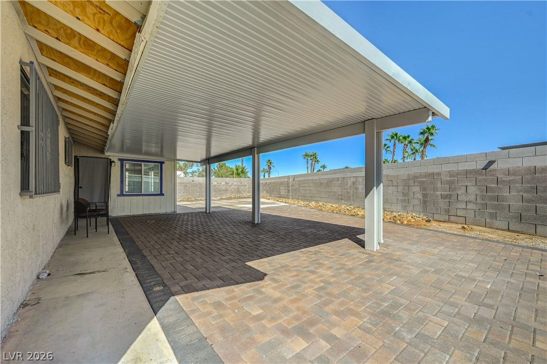 4442 Eureka Circle, Las Vegas, NV 89103 An expansive covered patio features clean brick pavers alongside a protective block privacy wall.
