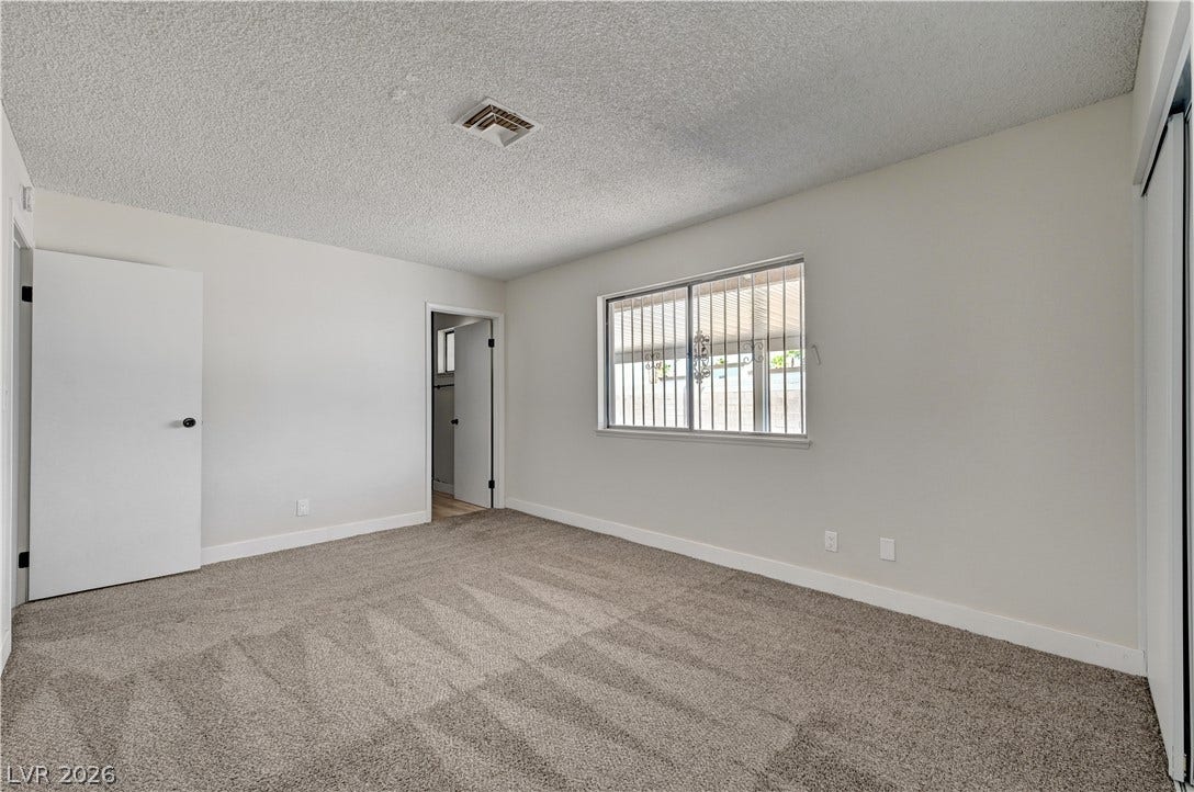 4442 Eureka Circle, Las Vegas, NV 89103 Plush carpeting and textured ceilings define this comfortable bedroom space.
