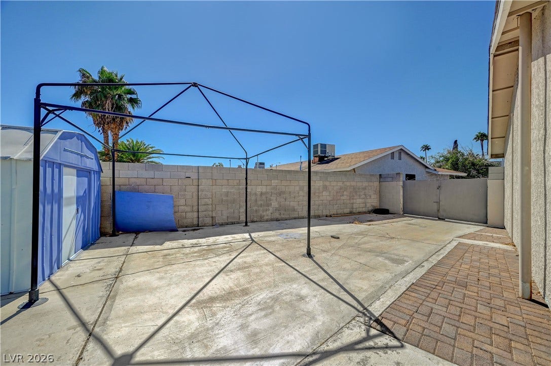 4442 Eureka Circle, Las Vegas, NV 89103 A spacious concrete and paved backyard area enclosed by a solid block wall.