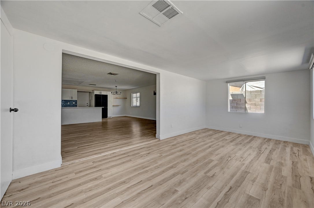 4442 Eureka Circle, Las Vegas, NV 89103 Smooth wood-look flooring and clean white walls anchor this versatile open-concept living space.