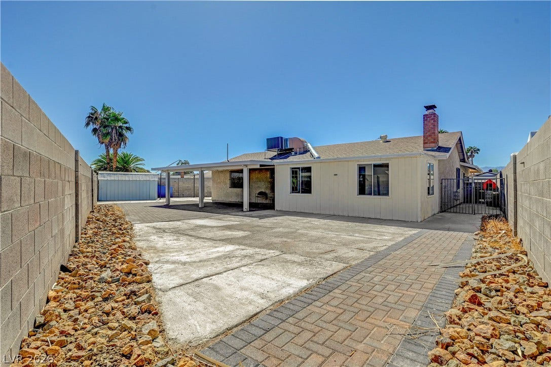 4442 Eureka Circle, Las Vegas, NV 89103 An expansive concrete patio and brick pathways highlight this enclosed backyard space.