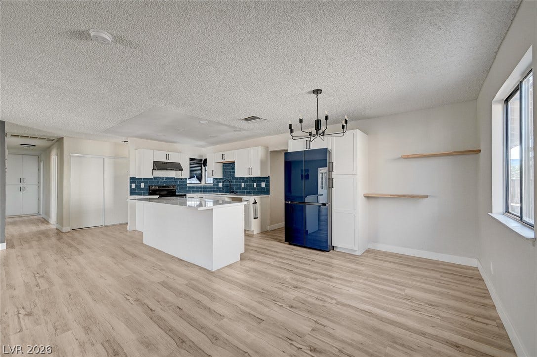 4442 Eureka Circle, Las Vegas, NV 89103 Clean lines and wood floors flow seamlessly through this modern, open-concept kitchen space.