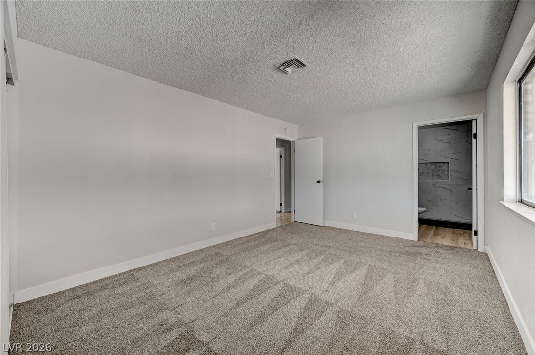 4442 Eureka Circle, Las Vegas, NV 89103 Plush carpeting and crisp white trim enhance this bedroom layout featuring an ensuite bath.