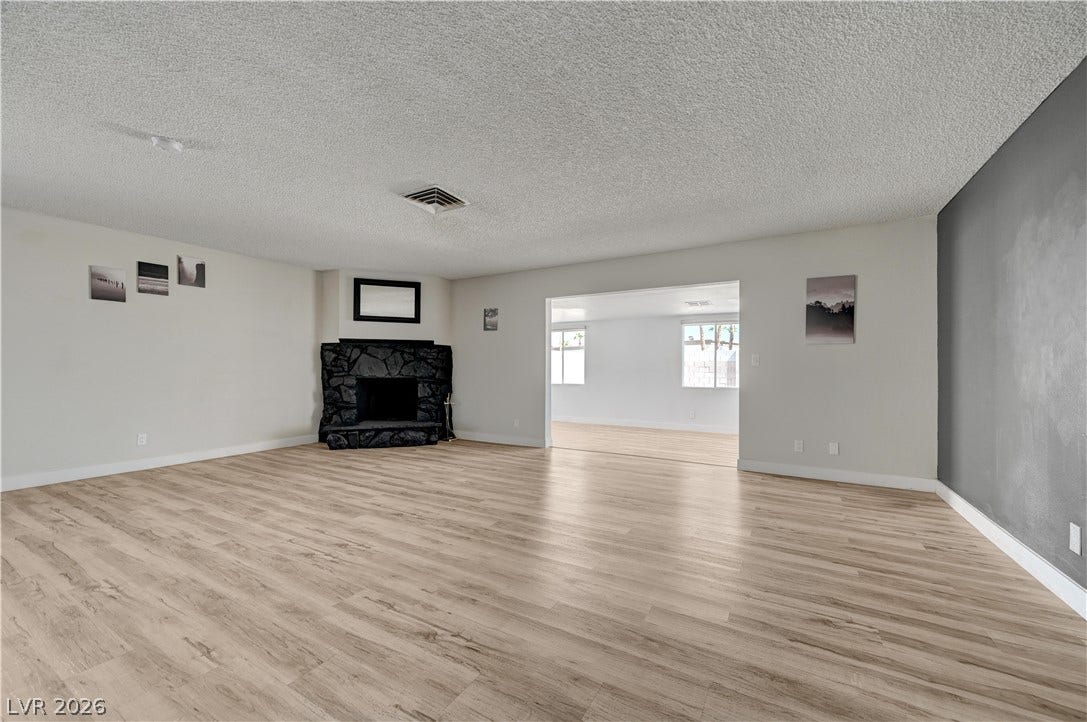4442 Eureka Circle, Las Vegas, NV 89103 An open living room centers around a stone fireplace and features durable vinyl flooring.