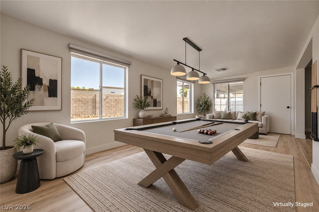 4442 Eureka Circle, Las Vegas, NV 89103 Smooth plaster walls and warm wood-style flooring frame this light-filled recreation space.