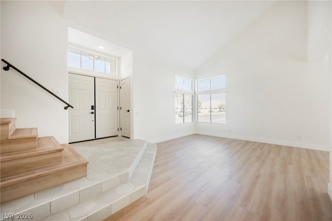Soaring vaulted ceilings and dual-surface flooring define this welcoming entrance foyer.