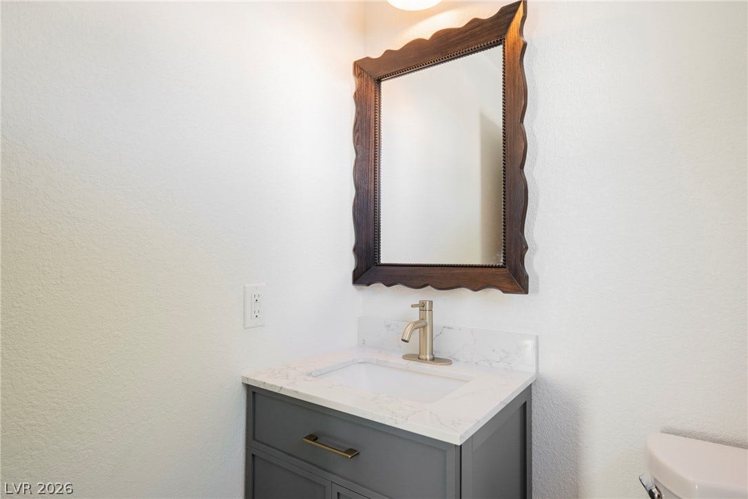 A stylish vanity with stone counters anchors this beautifully updated powder room.
