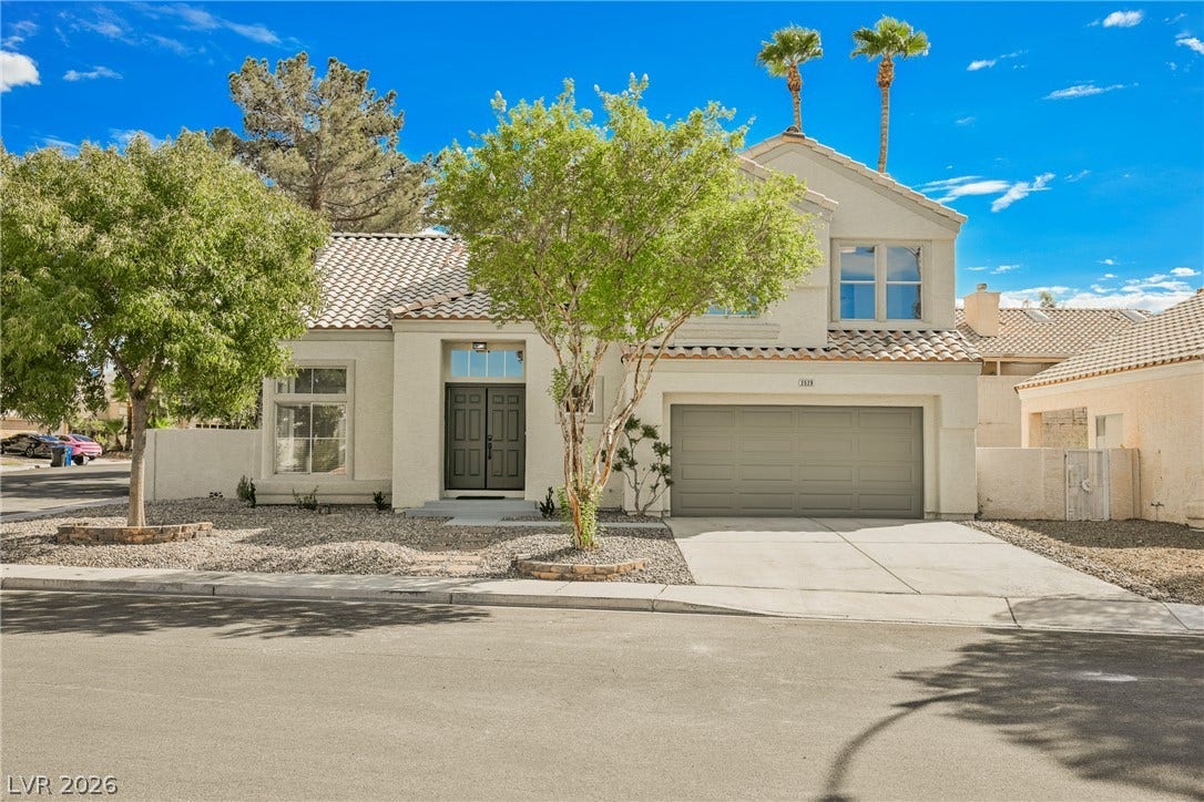Spanish tile roofing and a clean stucco exterior define this inviting two-story suburban home.
