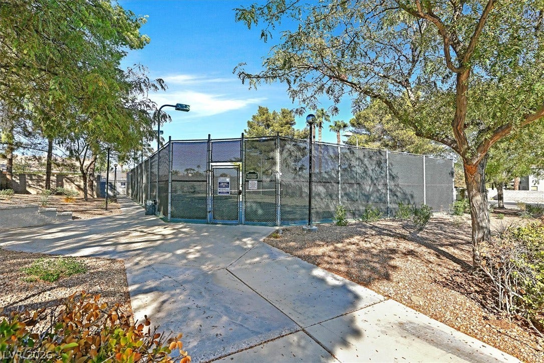 8830 Haviland Road, Las Vegas, NV 89123 Concrete walkways lead directly to a fenced community court shaded by mature desert trees.