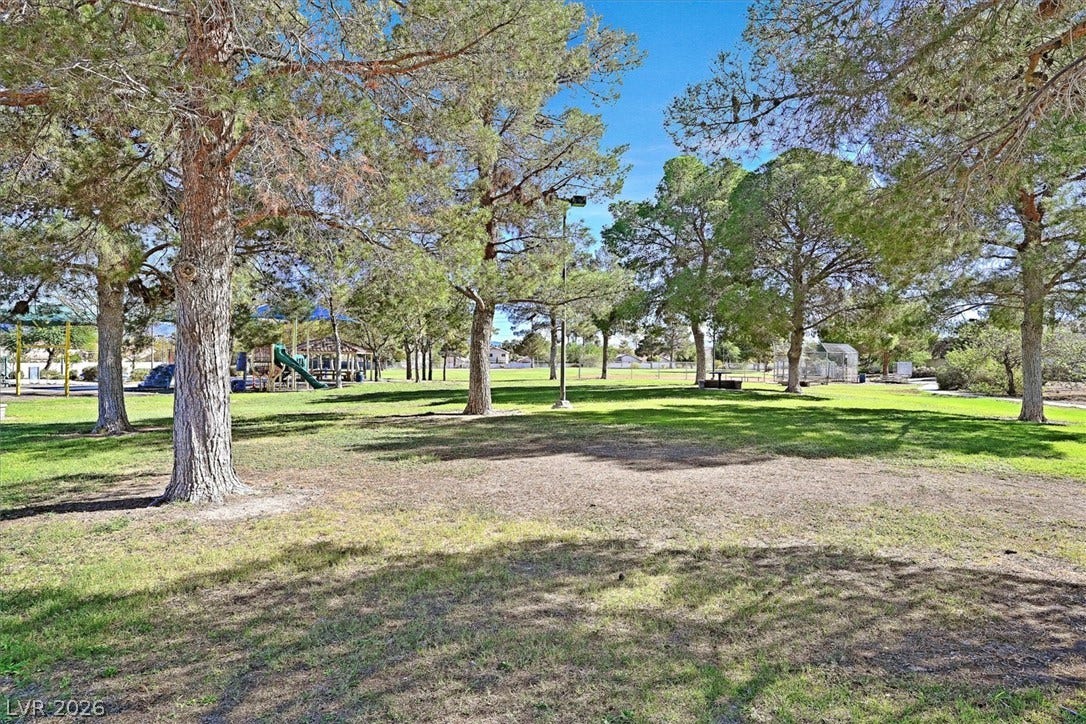 8830 Haviland Road, Las Vegas, NV 89123 Mature trees shade a sprawling grassy park featuring integrated playground structures.