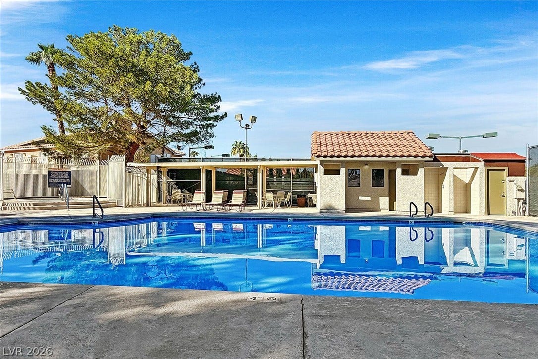 8830 Haviland Road, Las Vegas, NV 89123 Clear blue waters reflect the poolside cabana and surrounding tile-roof structures under sunny skies.