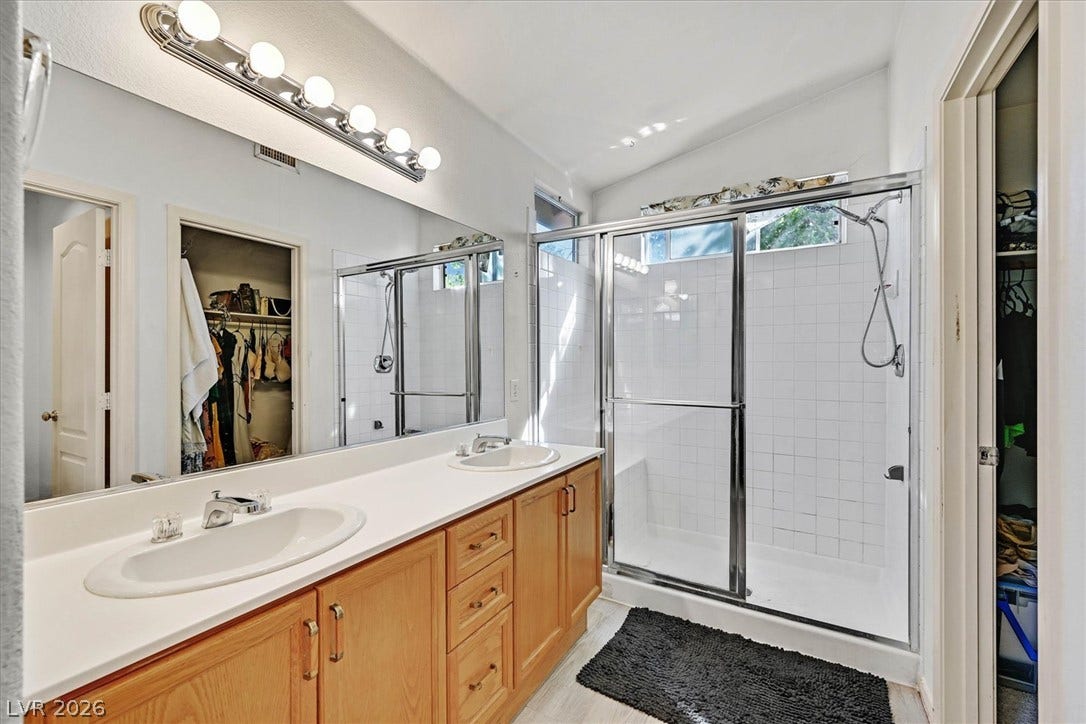 8830 Haviland Road, Las Vegas, NV 89123 Double vanities and a tiled walk-in shower define this bright, functional bathroom layout.