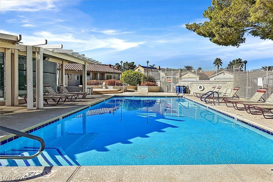 8830 Haviland Road, Las Vegas, NV 89123 A sparkling community swimming pool sits surrounded by a concrete patio and security fencing.