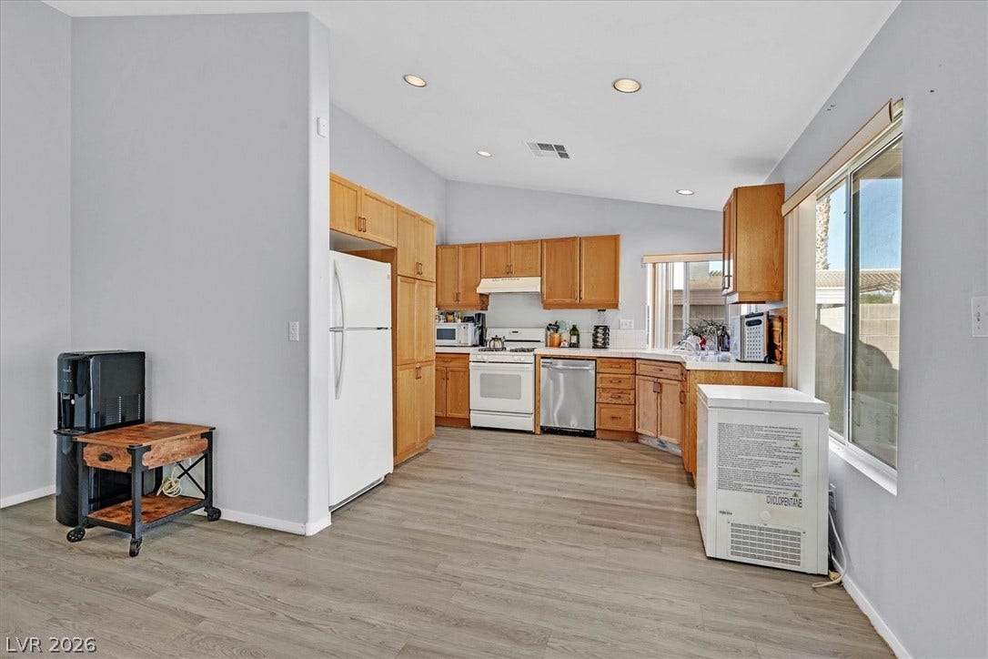 8830 Haviland Road, Las Vegas, NV 89123 Ample wooden cabinetry and durable vinyl flooring highlight this functional kitchen space.