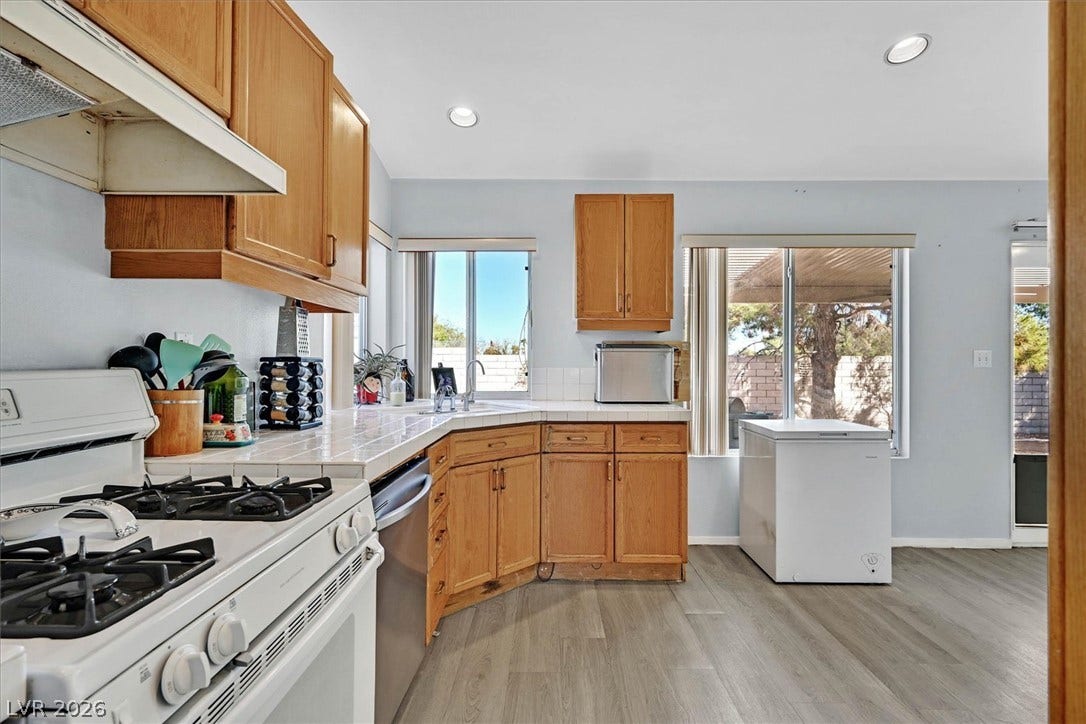 8830 Haviland Road, Las Vegas, NV 89123 Warm wood cabinetry and tile countertops accent this functional cooking space with direct patio access.