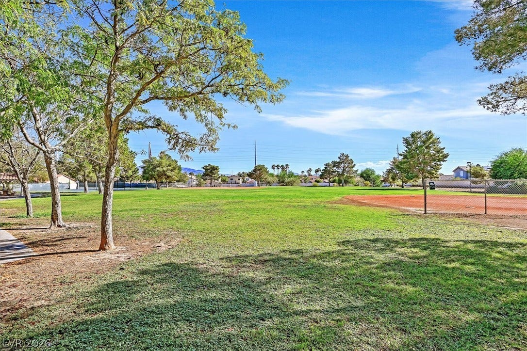 8830 Haviland Road, Las Vegas, NV 89123 Mature trees shade the grassy edges of a neighborhood park featuring a baseball diamond.