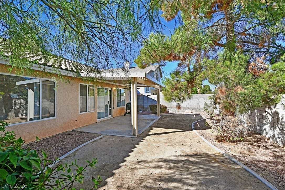 8830 Haviland Road, Las Vegas, NV 89123 Mature trees shade a covered concrete patio overlooking the low-maintenance backyard space.