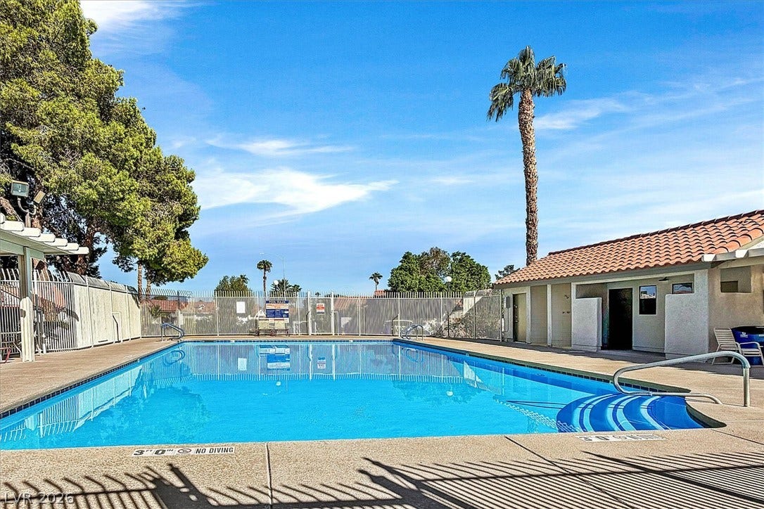 8830 Haviland Road, Las Vegas, NV 89123 A pristine community swimming pool is framed by safety fencing under a bright blue sky.
