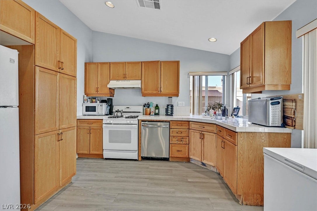 8830 Haviland Road, Las Vegas, NV 89123 Vaulted ceilings and warm wood cabinetry define this functional, light-filled kitchen space.