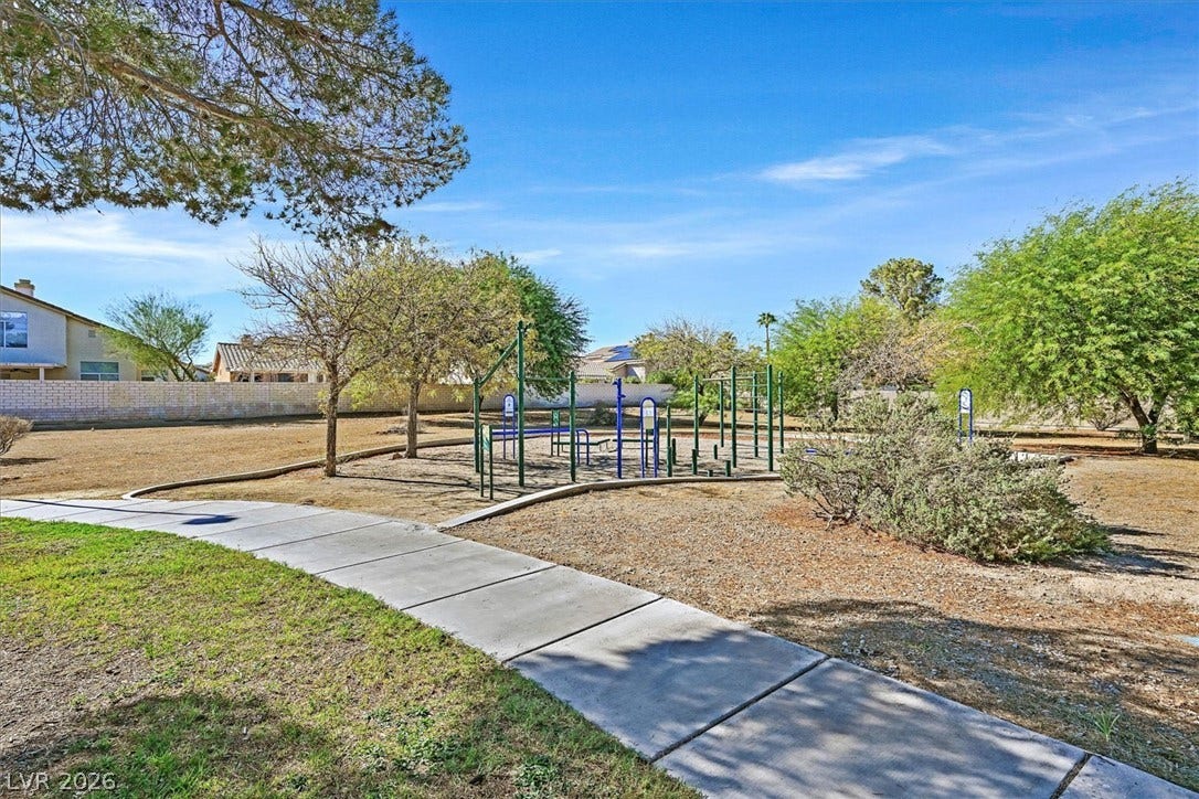 8830 Haviland Road, Las Vegas, NV 89123 A paved walkway winds toward a playground area under a clear blue sky.