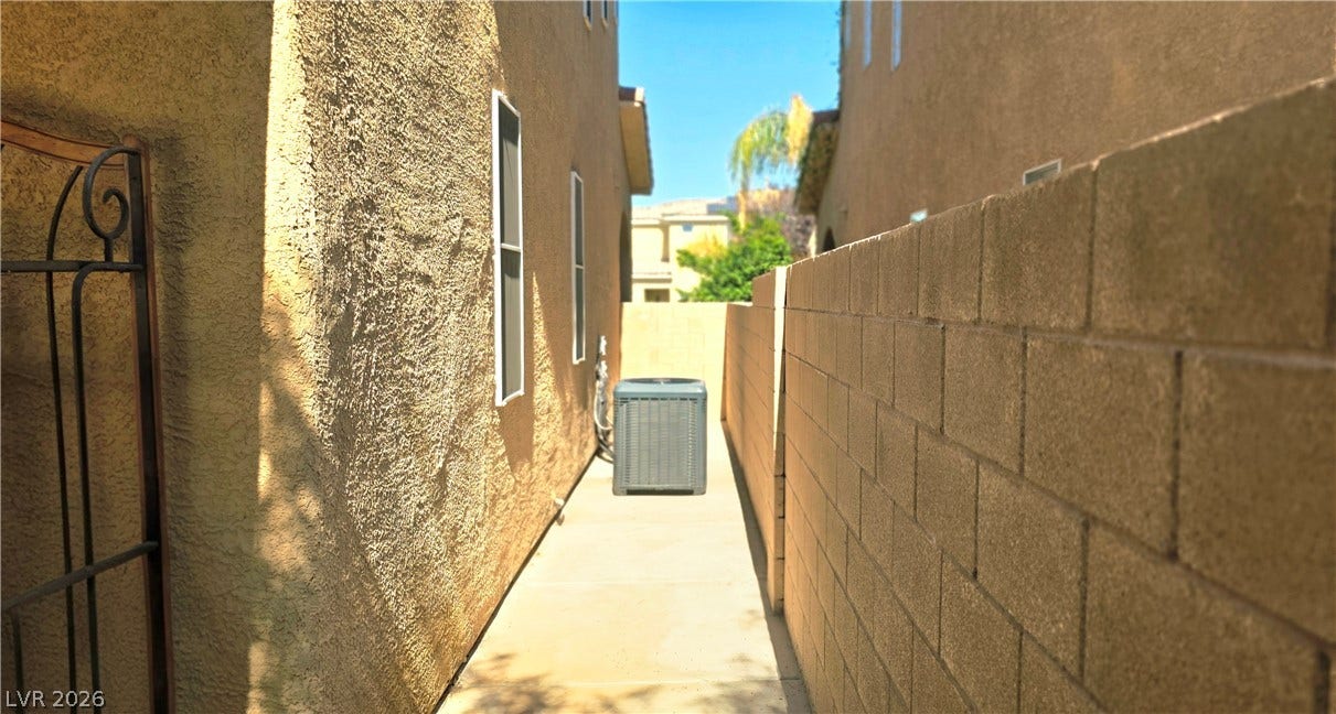 5087 Caprock Canyon Avenue, Las Vegas, NV 89139 A paved side pathway runs alongside the textured stucco exterior and block privacy wall.