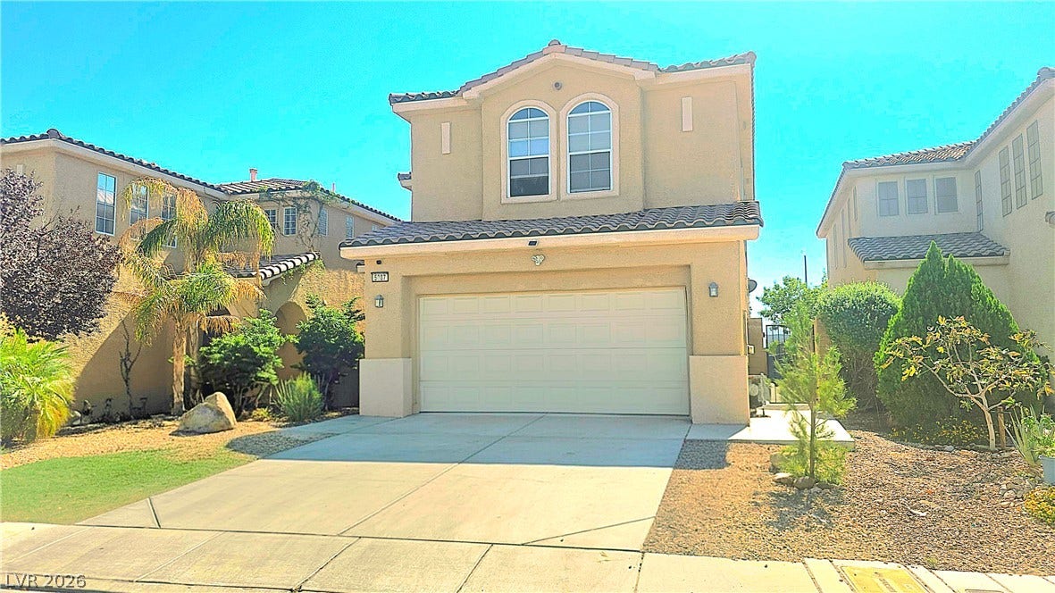 5087 Caprock Canyon Avenue, Las Vegas, NV 89139 A spacious concrete driveway leads directly to the attached two-car garage of this multi-level home.