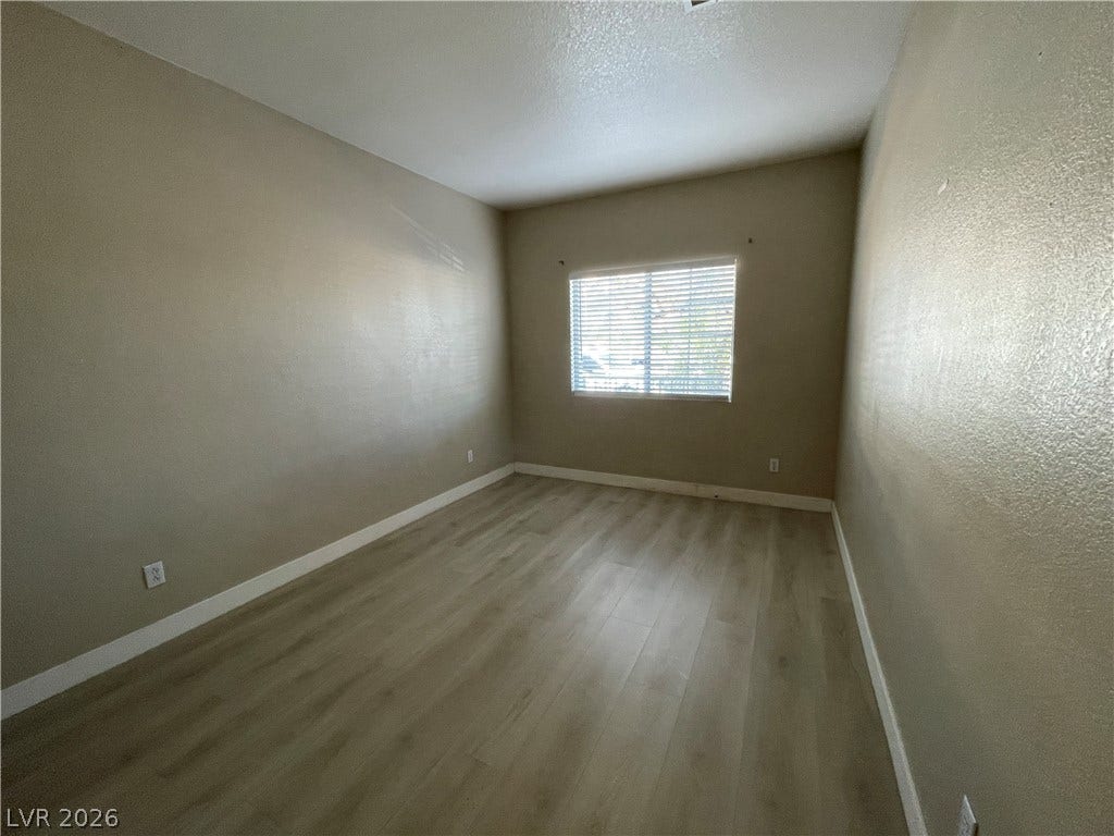 7873 Blue Brook Drive, Las Vegas, NV 89147 Smooth wood-look flooring and a wide window create a versatile, inviting space.