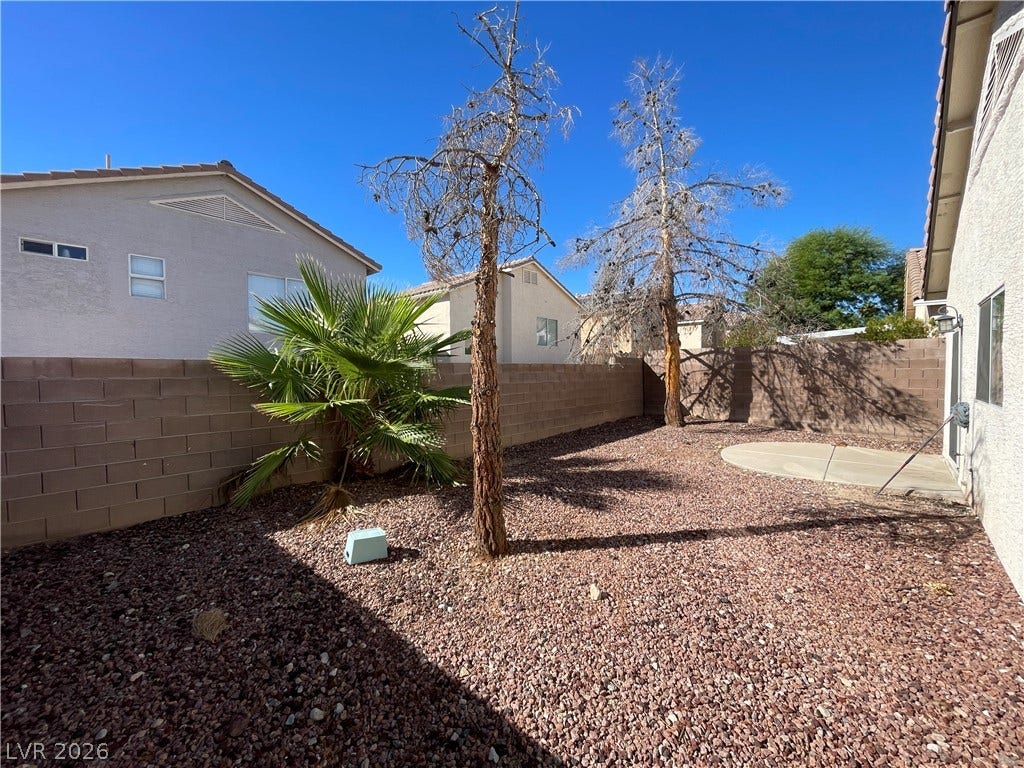 7873 Blue Brook Drive, Las Vegas, NV 89147 A block wall privacy fence encloses the low-maintenance gravel backyard with a circular concrete patio.
