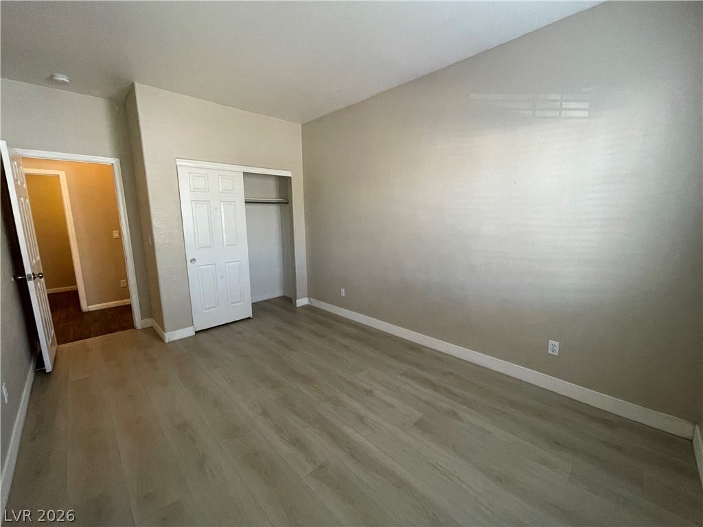 7873 Blue Brook Drive, Las Vegas, NV 89147 Smooth wood-look flooring sets a modern foundation under a vaulted ceiling in this spacious bedroom.