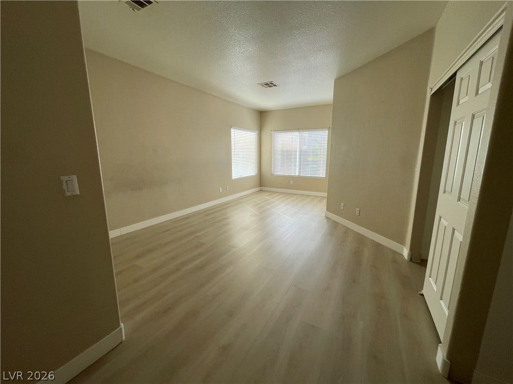 7873 Blue Brook Drive, Las Vegas, NV 89147 Hardwood floors and natural light from multiple windows define this versatile living area.